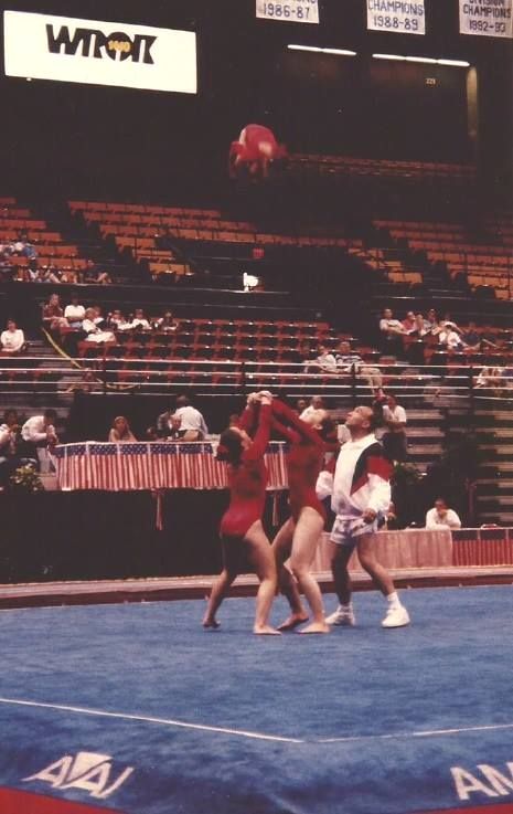A group of gymnasts are on a blue mat in front of an aai sign