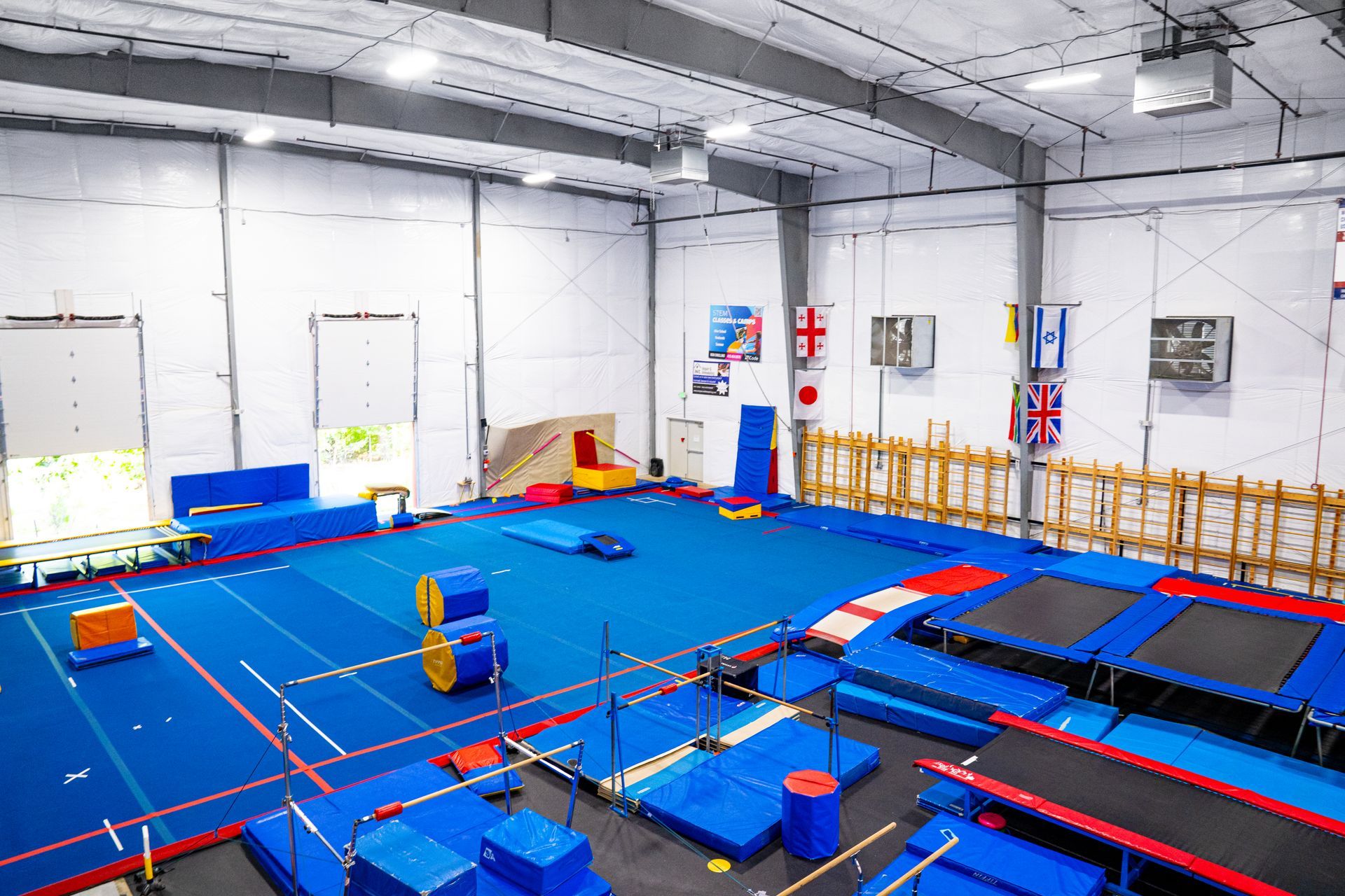 A large gym filled with blue mats and trampolines.