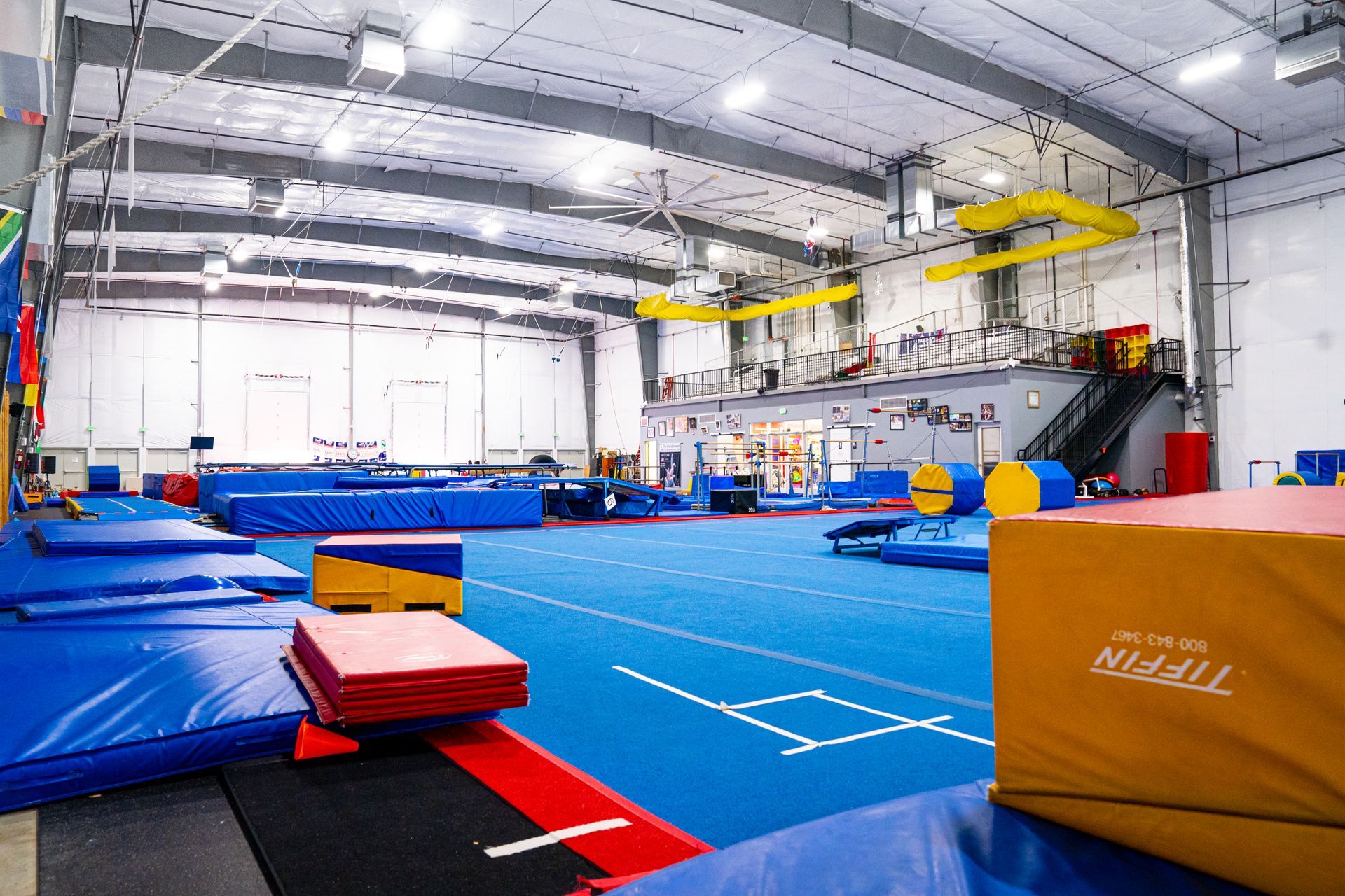 A large gym filled with lots of mats and equipment.