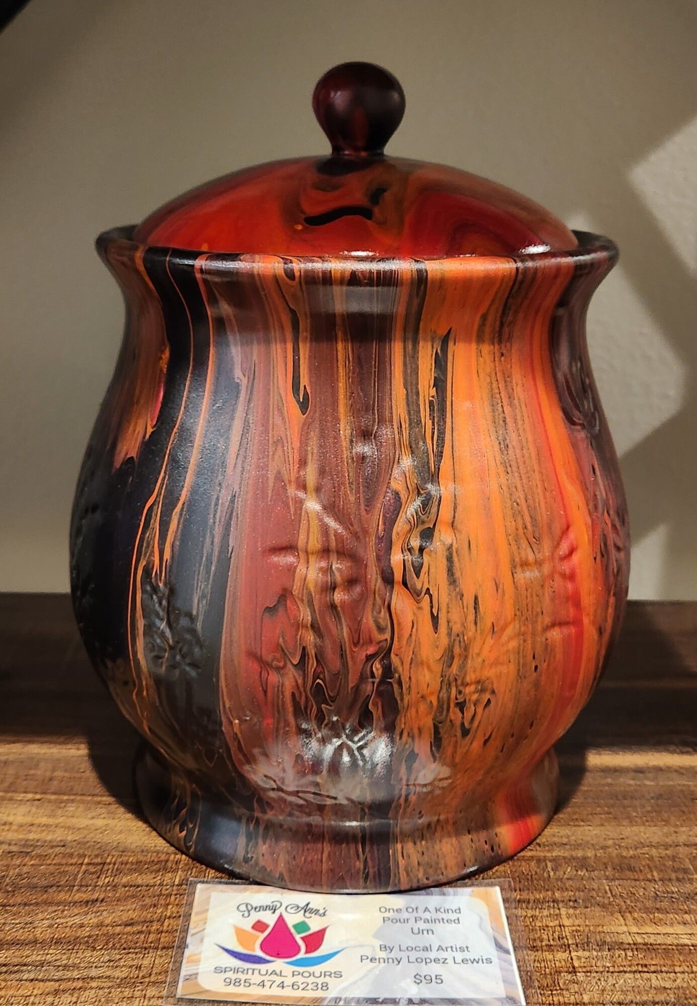 Glazed ceramic jar with lid; orange, black, and brown vertical streaks.