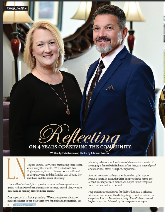 A smiling couple, Harry in a blue suit,  Lisa in black, posing in front of a mirror, for an article about community service.