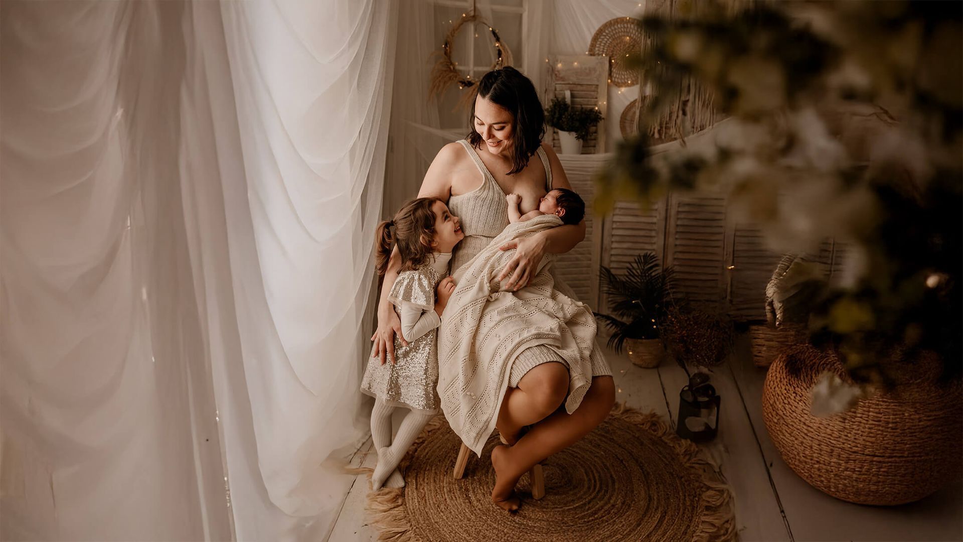 Una mujer está sentada en una roca sosteniendo un bebé.