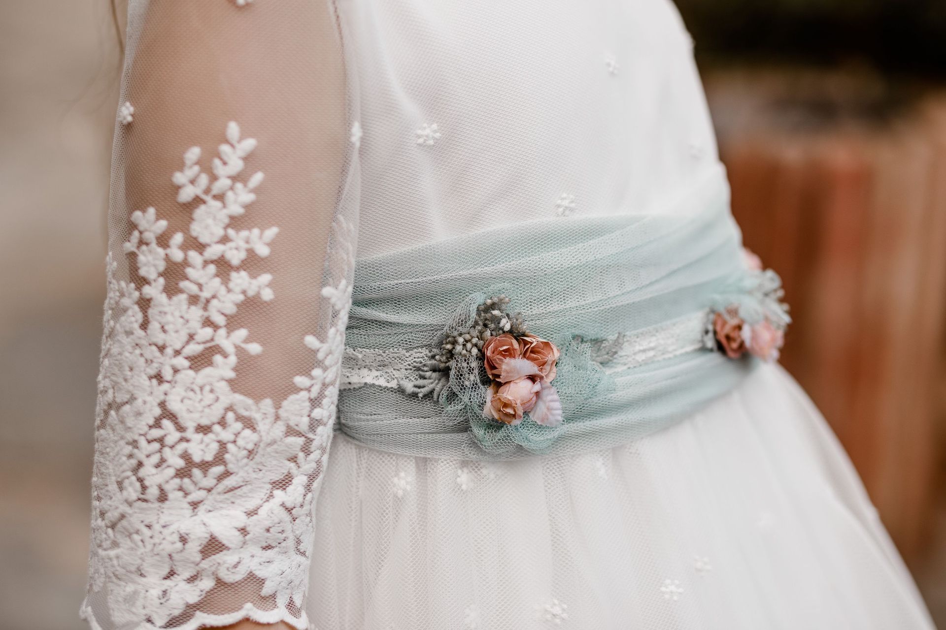 Un primer plano de una mujer que lleva un vestido blanco con una faja azul.