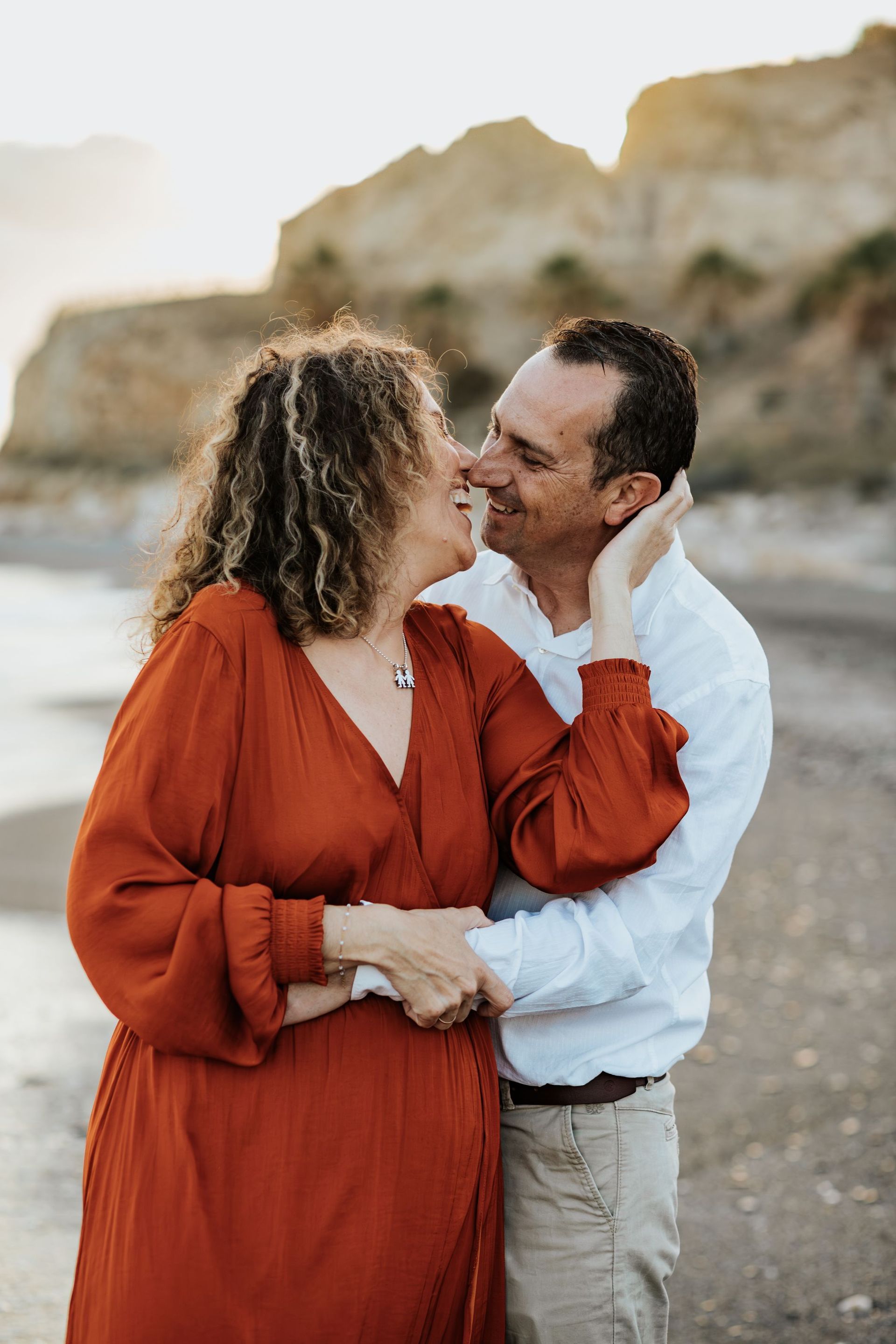 Un hombre y una mujer se besan en la playa.