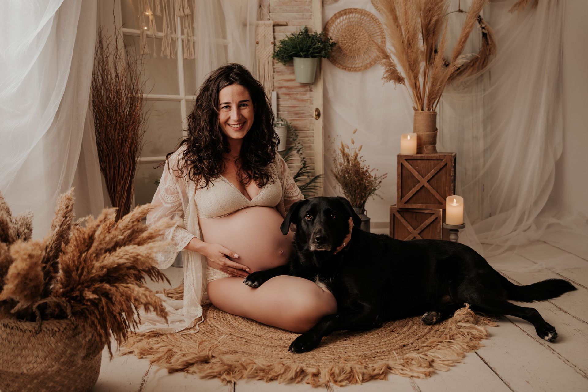una mujer embarazada está sentada en el suelo con un perro.
