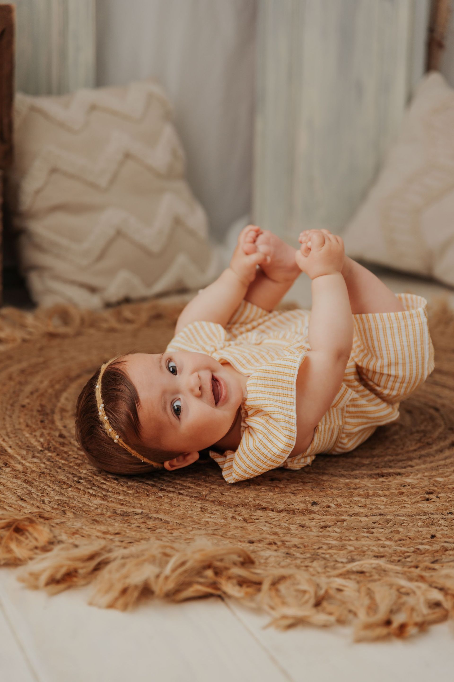 Una niña está acostada boca arriba sobre una alfombra.