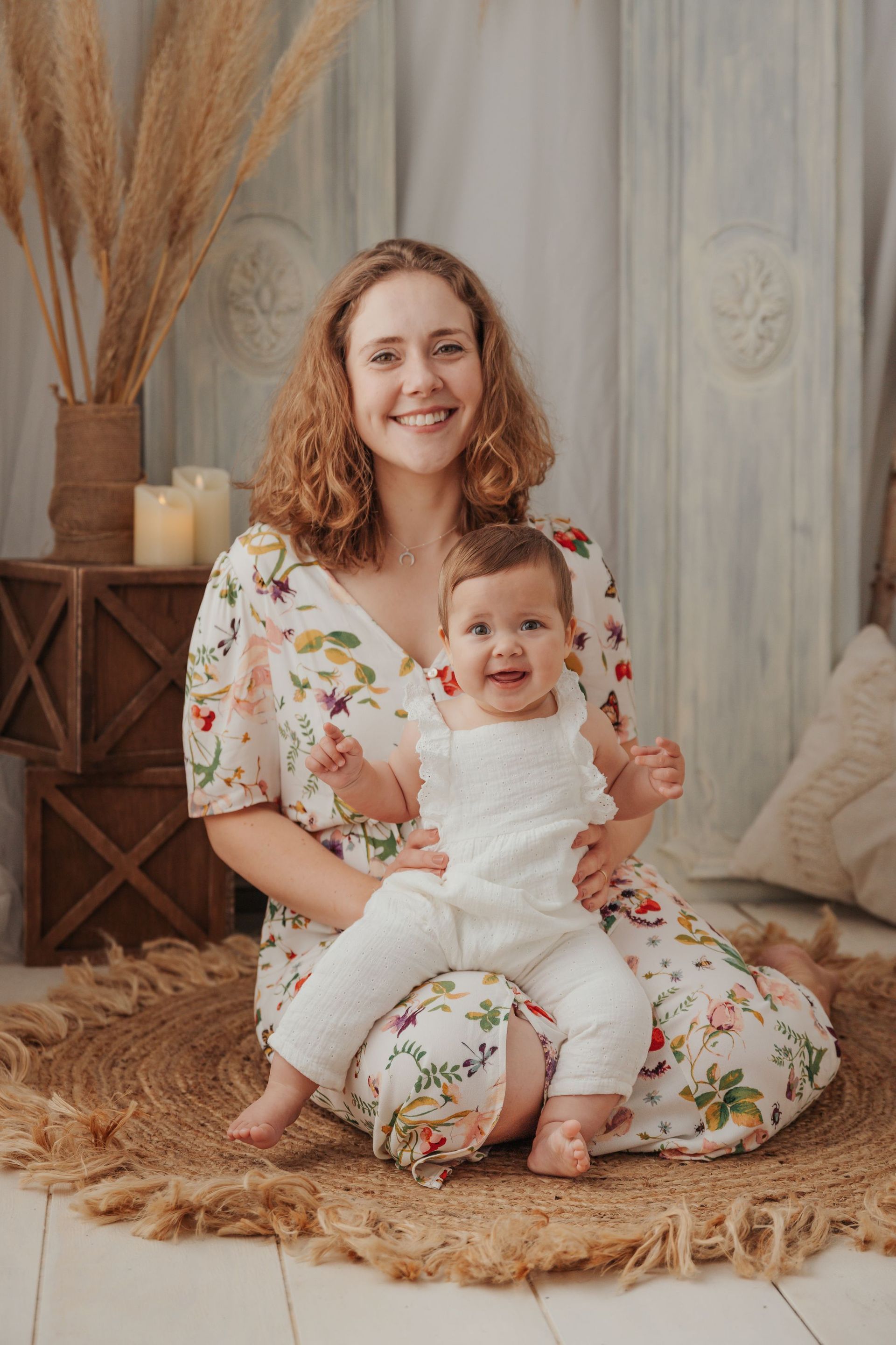 Una mujer está sentada en el suelo sosteniendo un bebé.