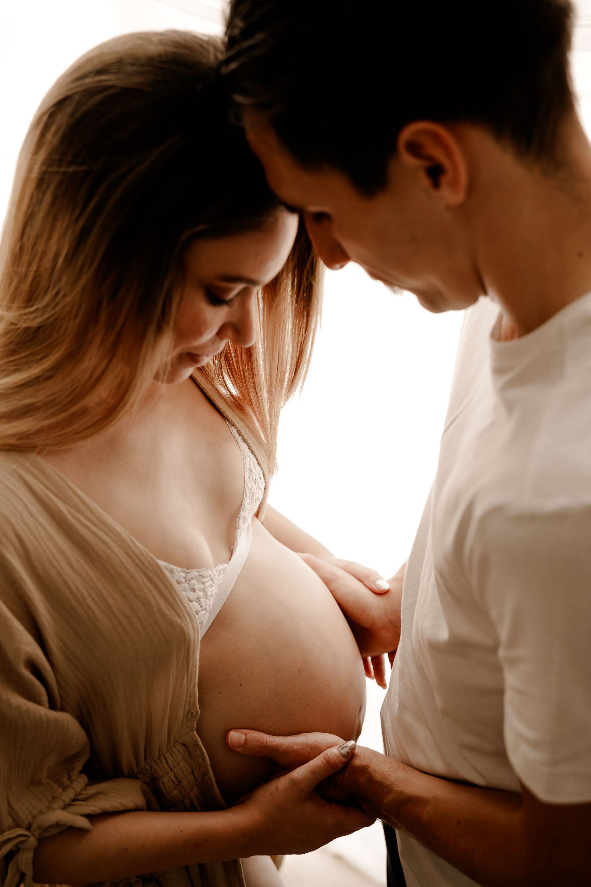 Un hombre y una mujer embarazada se miran.