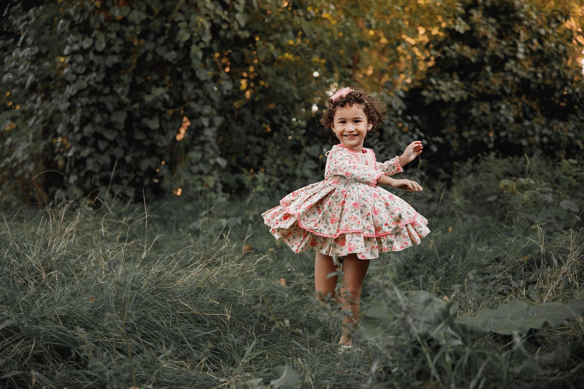 Una niña con un vestido está parada en la hierba.