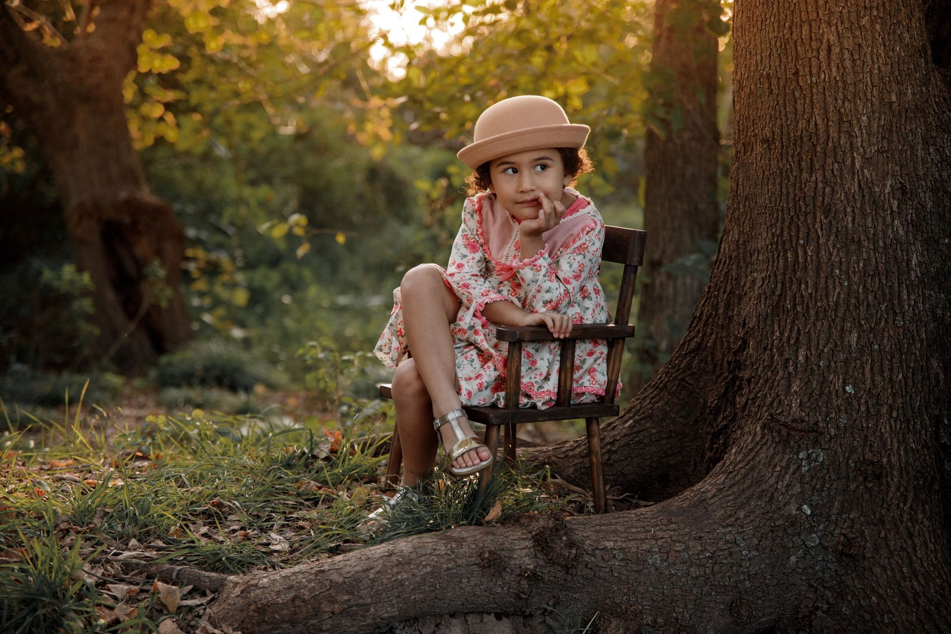 Una niña está sentada en un banco en el bosque.