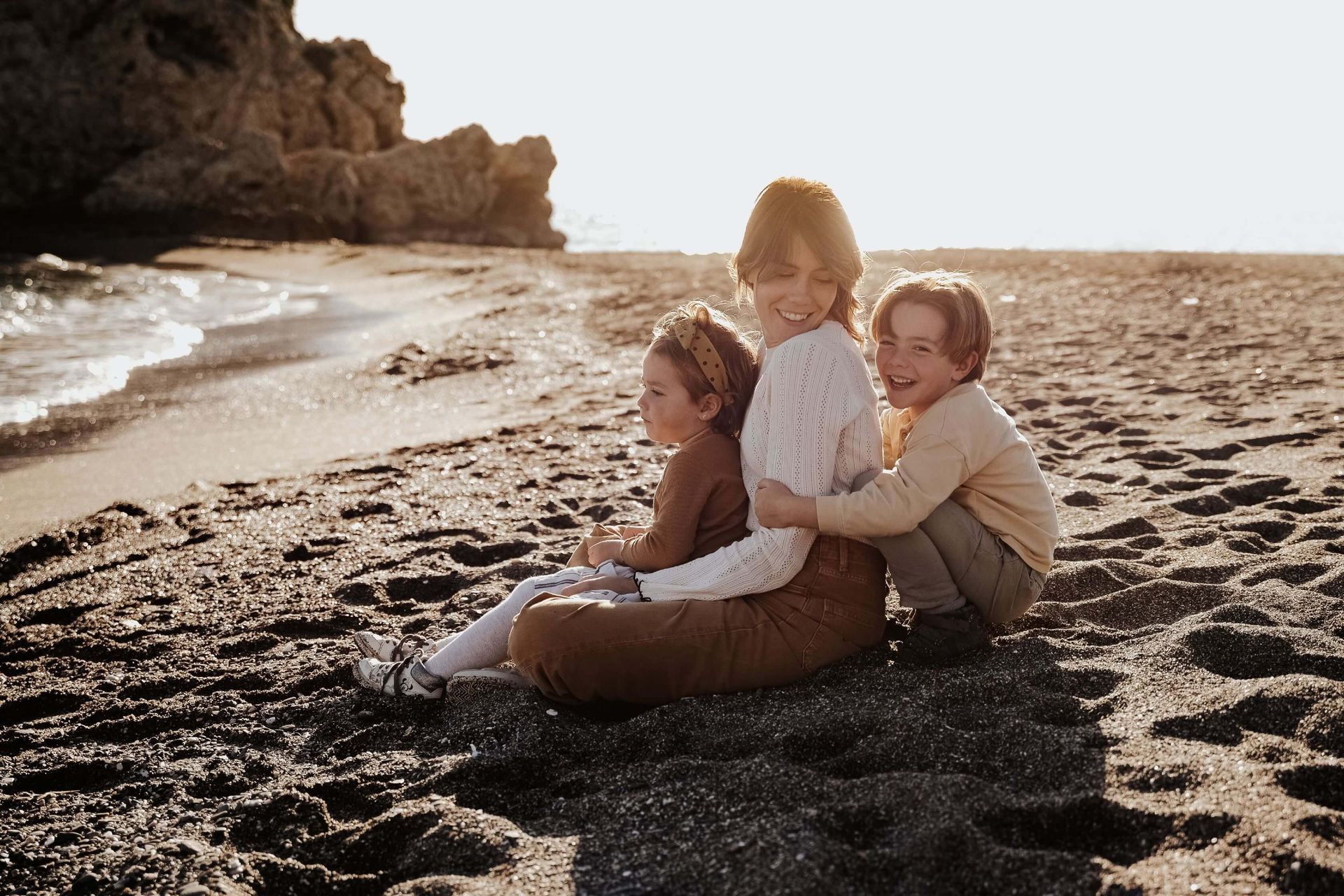 Una familia está sentada en un sofá frente a un árbol de Navidad.