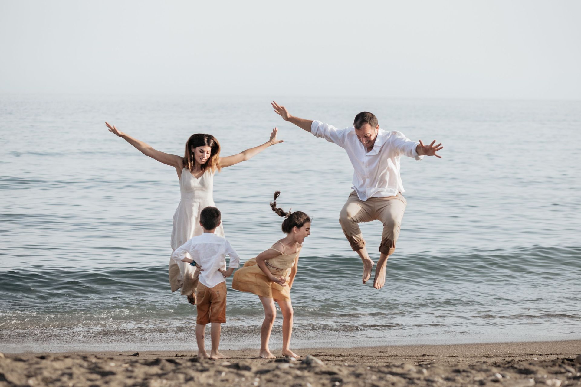 Una familia está saltando en el aire en la playa.