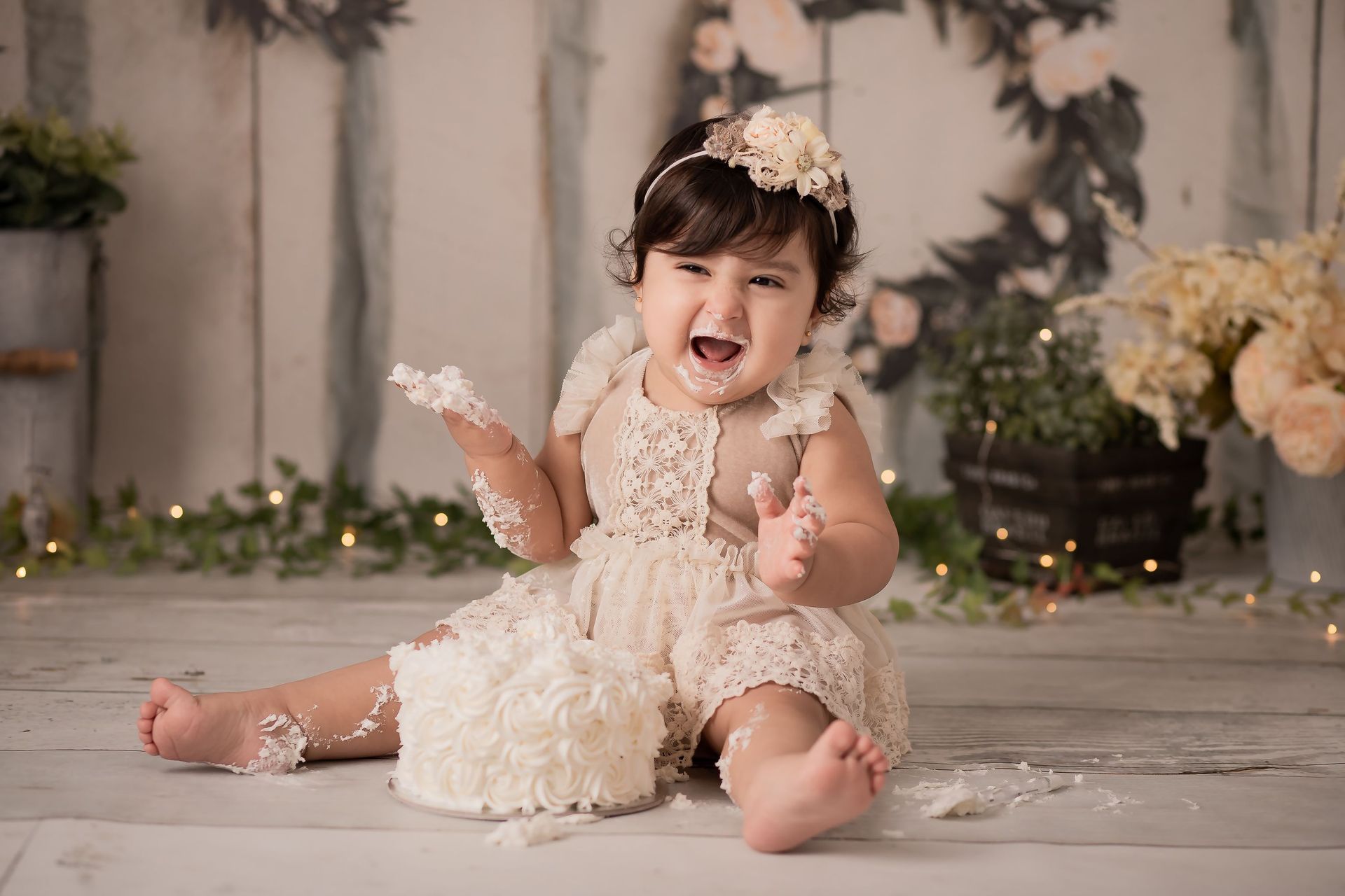 Una niña está acostada en un piso de madera sosteniendo un pastel.