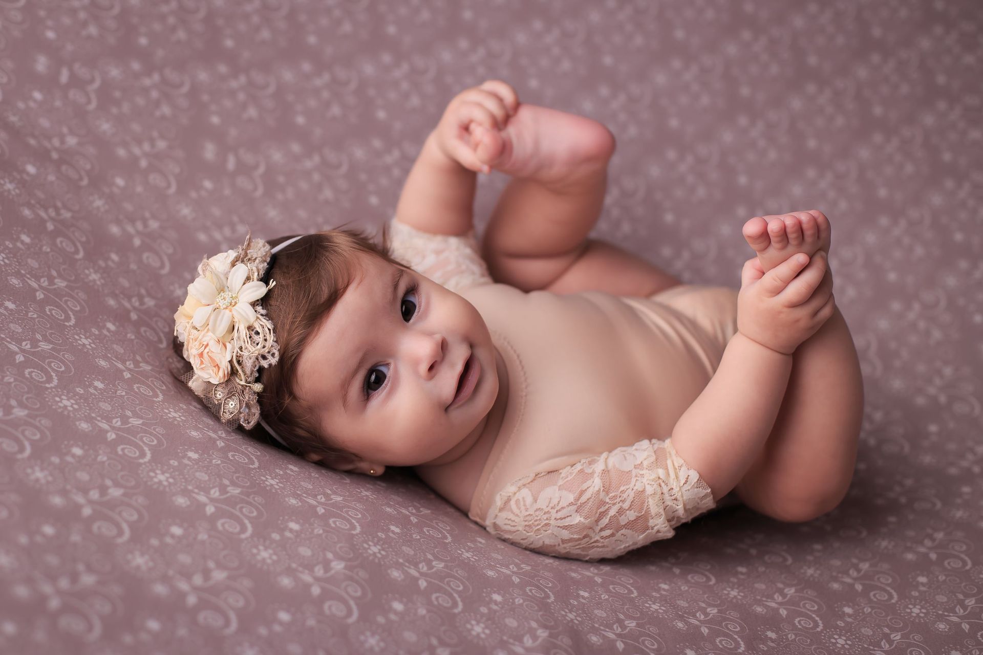 un bebé con una diadema está acostado en la cama .