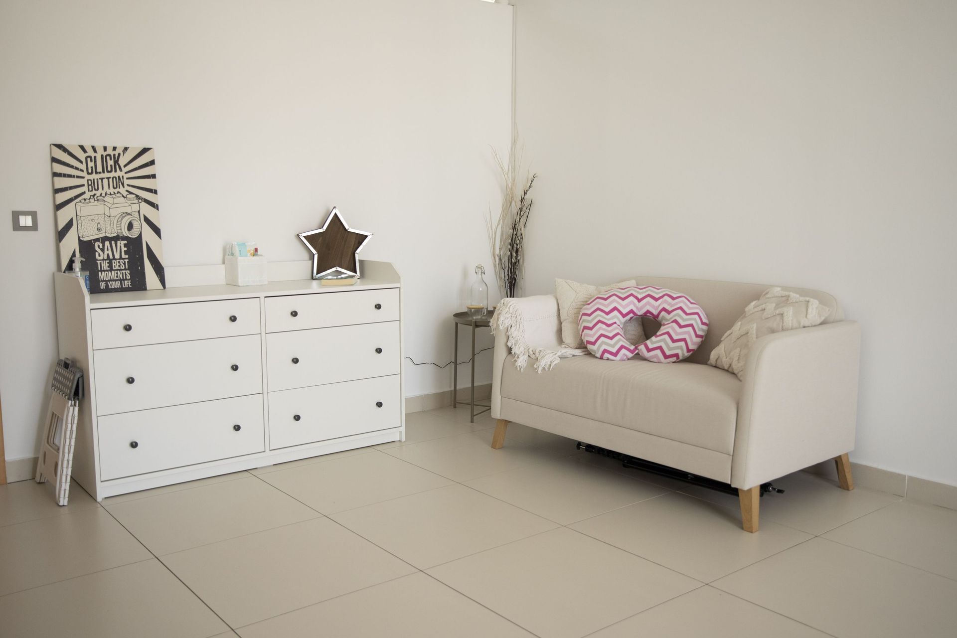 Hay un sofá y una cómoda en la habitación.