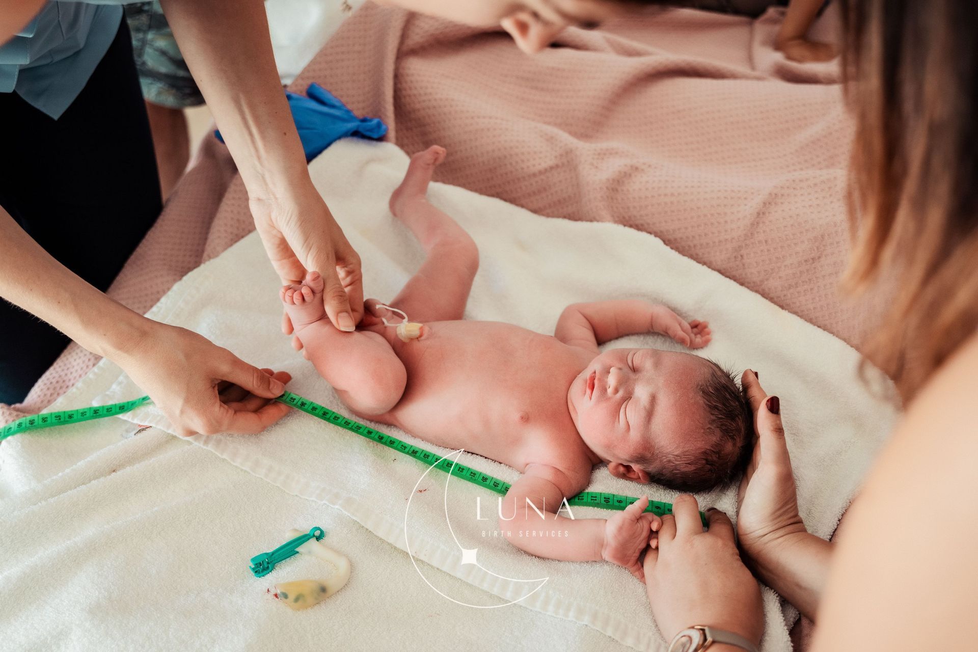 Un grupo de mujeres está midiendo a un bebé recién nacido.