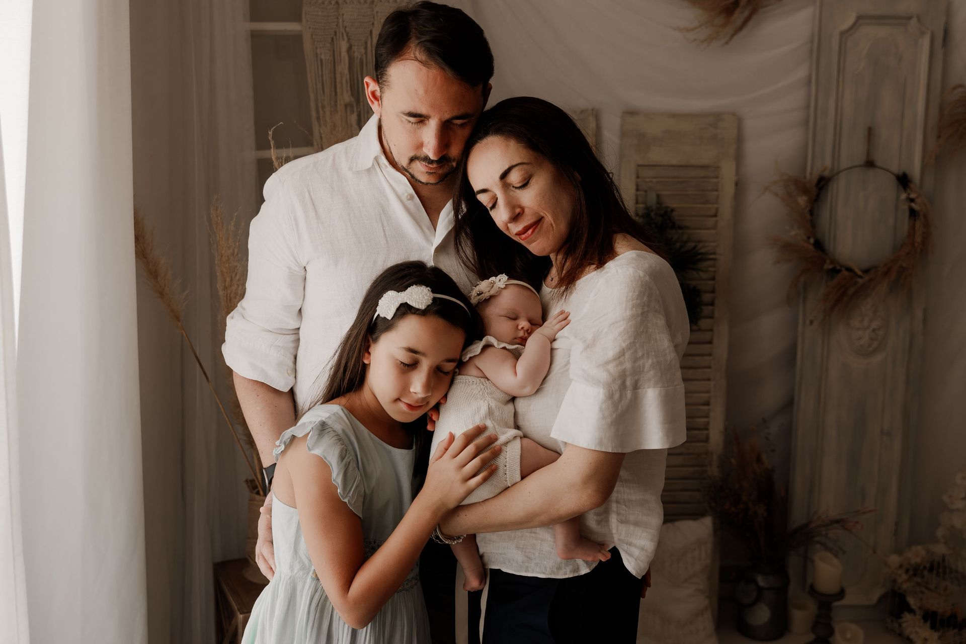 Una familia posa para una fotografía con un bebé recién nacido.