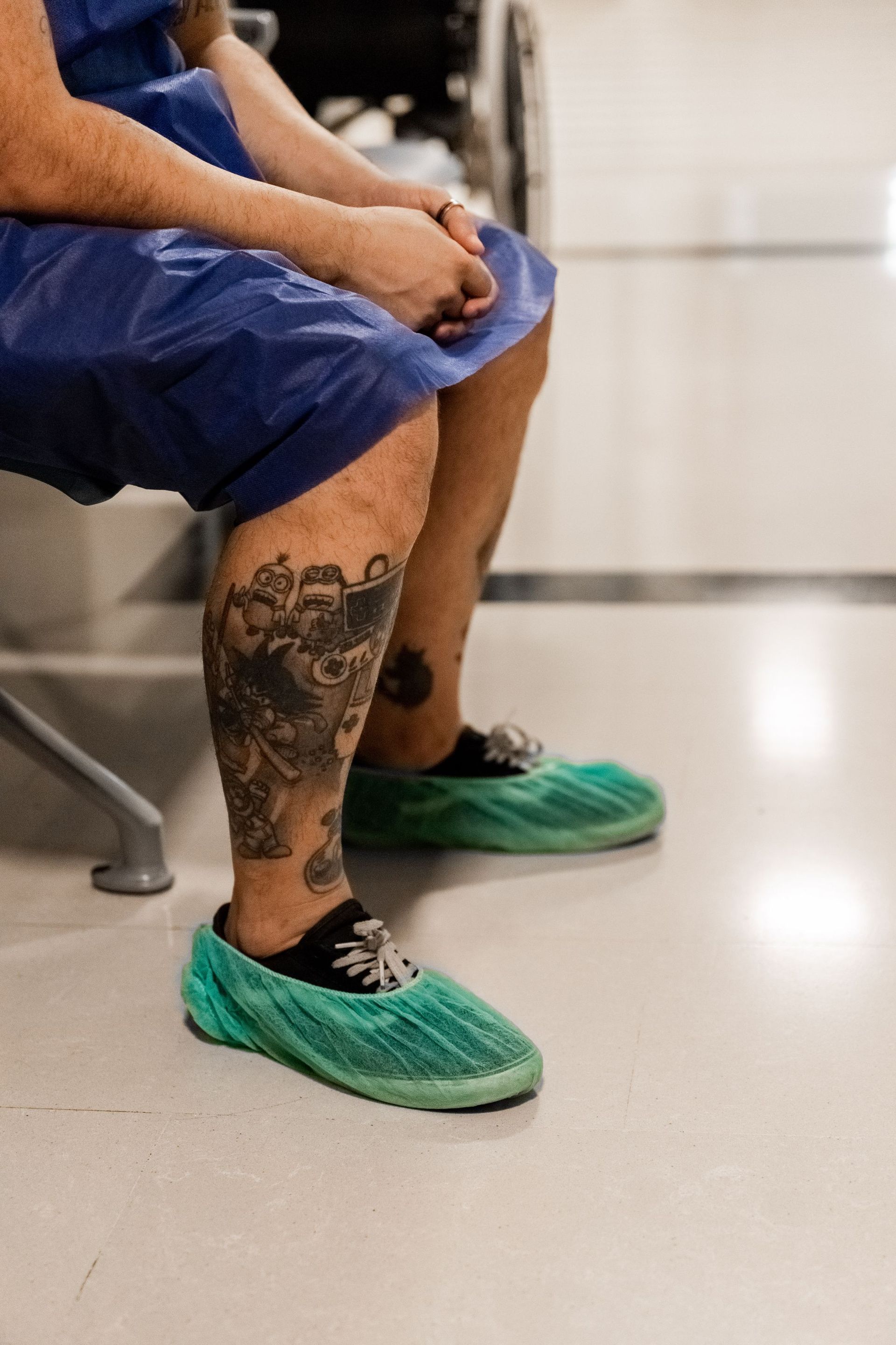 Una persona con un tatuaje en la pierna está sentada en una silla.