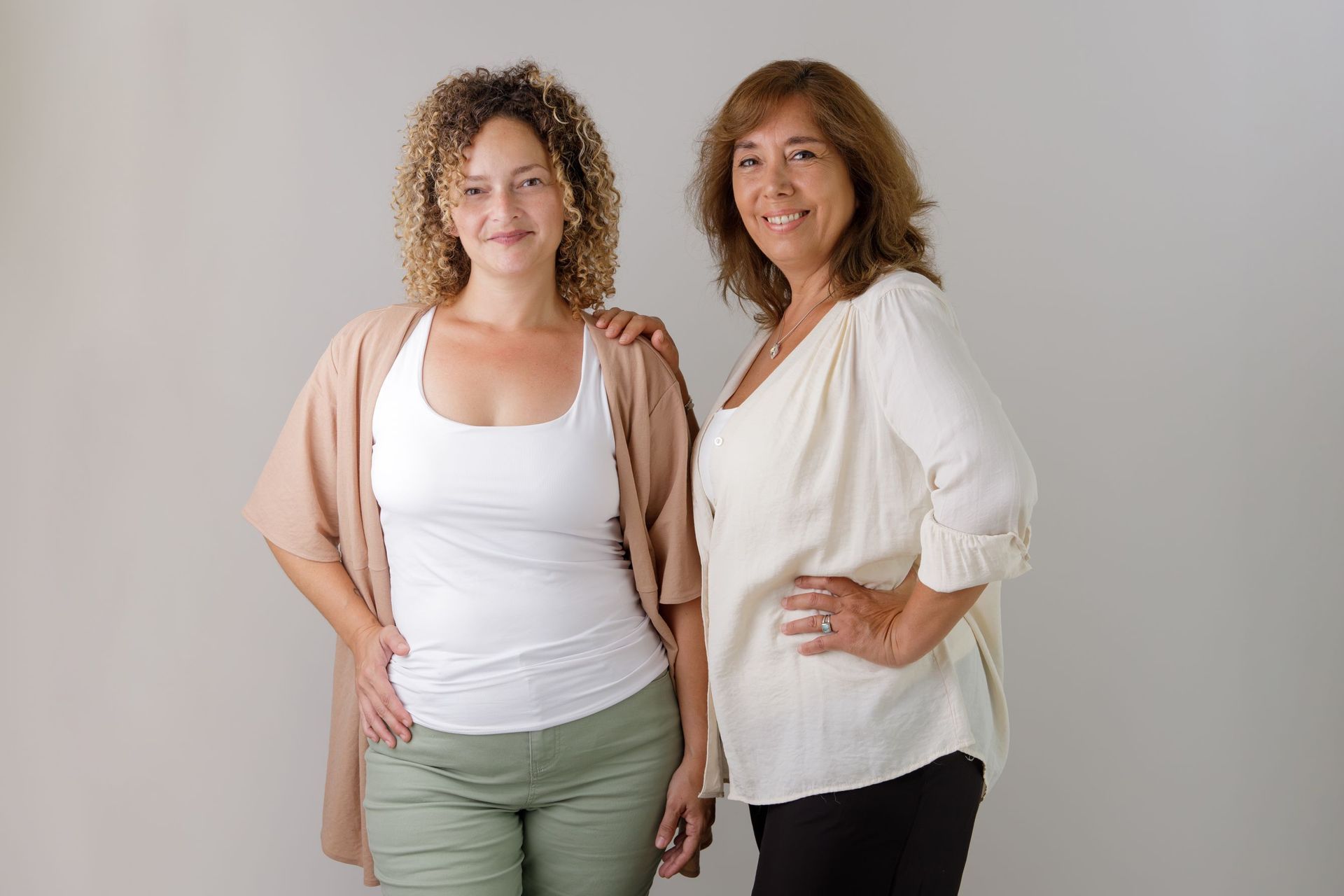 Dos mujeres están paradas una al lado de la otra y posan para una fotografía.