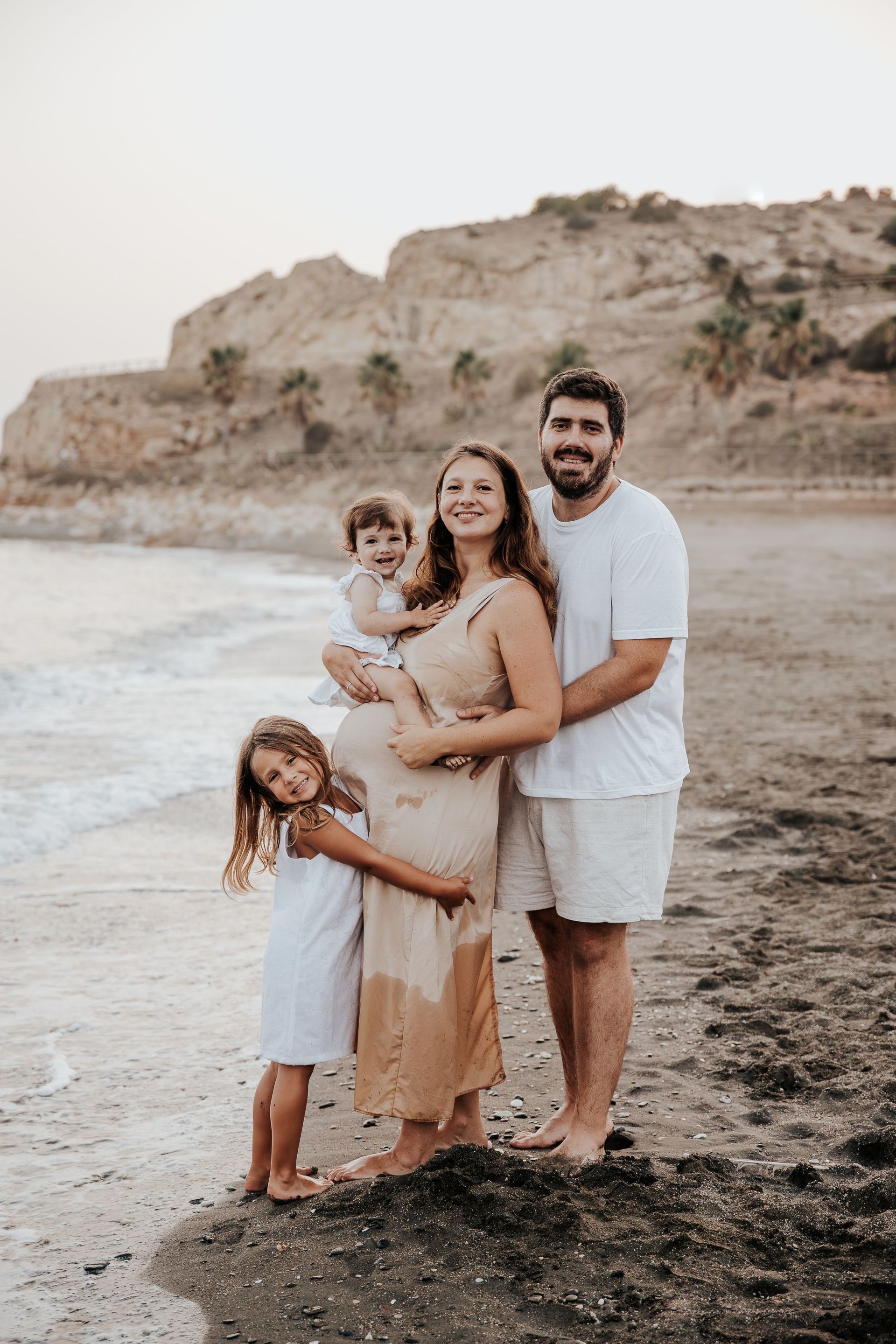 Una familia posa para una foto en la playa.