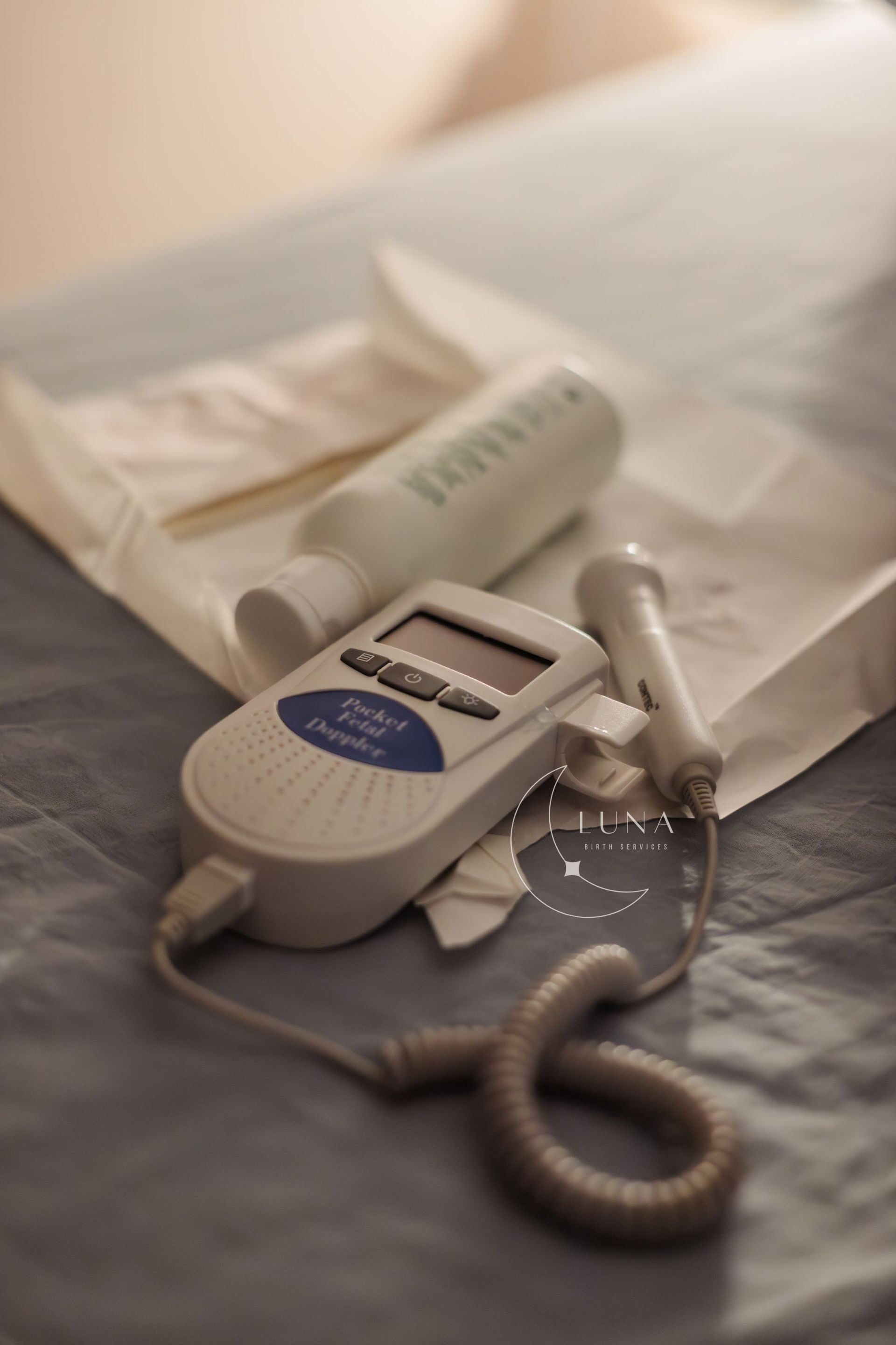 Un dispositivo Doppler fetal está sobre una cama.