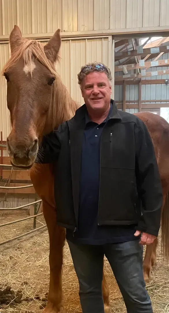 A man in black jacket with a horse