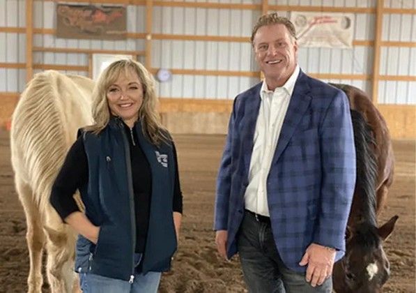 A woman and a boy smile in front of a mountain