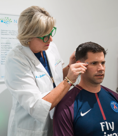 A man wearing a fly emirates shirt is being examined by a doctor