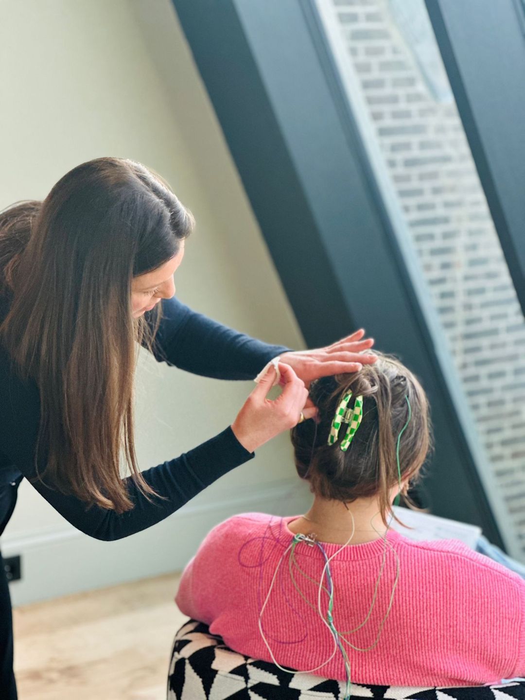 A man is getting his hair cut by a woman