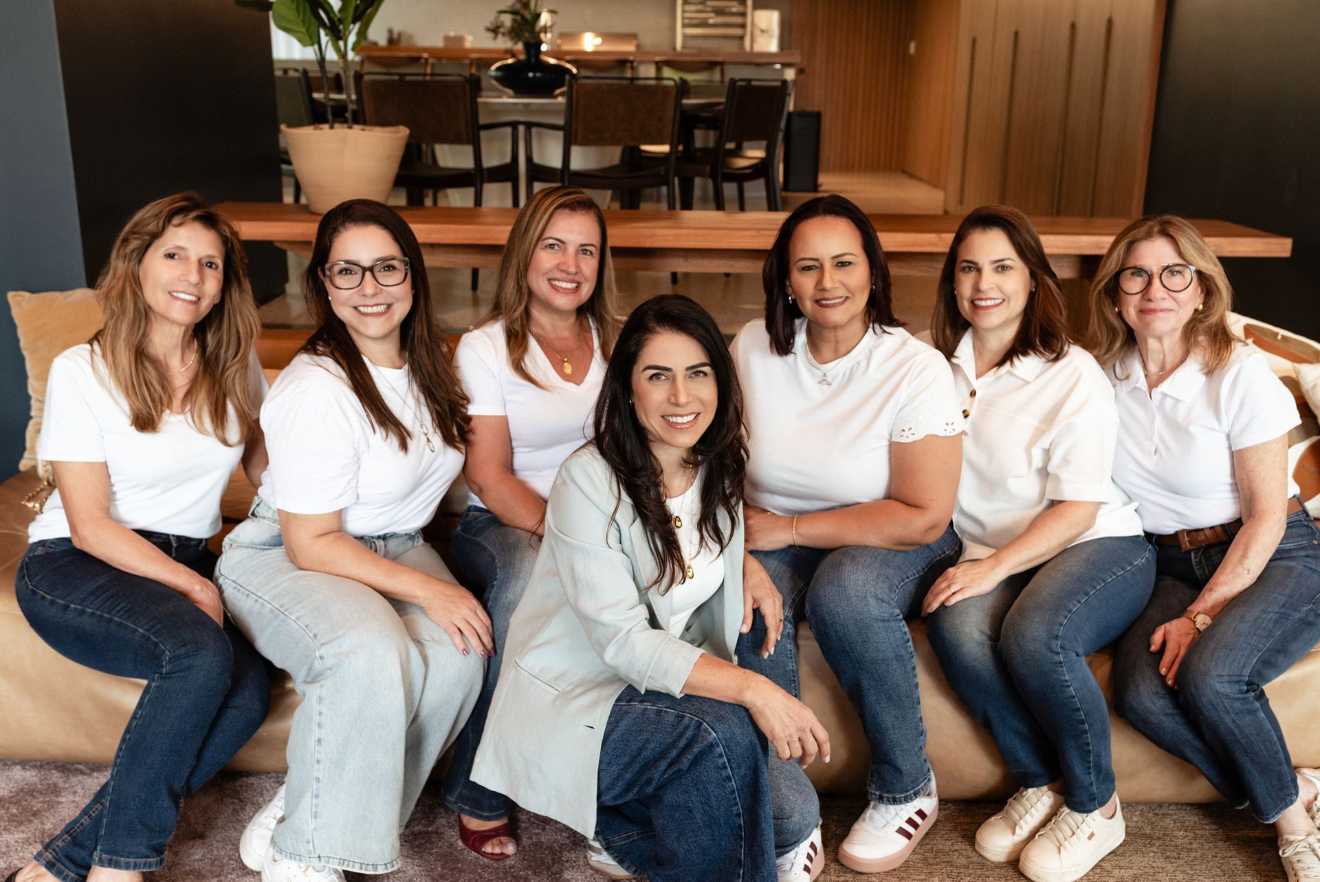 Um grupo de mulheres está posando para uma foto sentadas em um sofá.