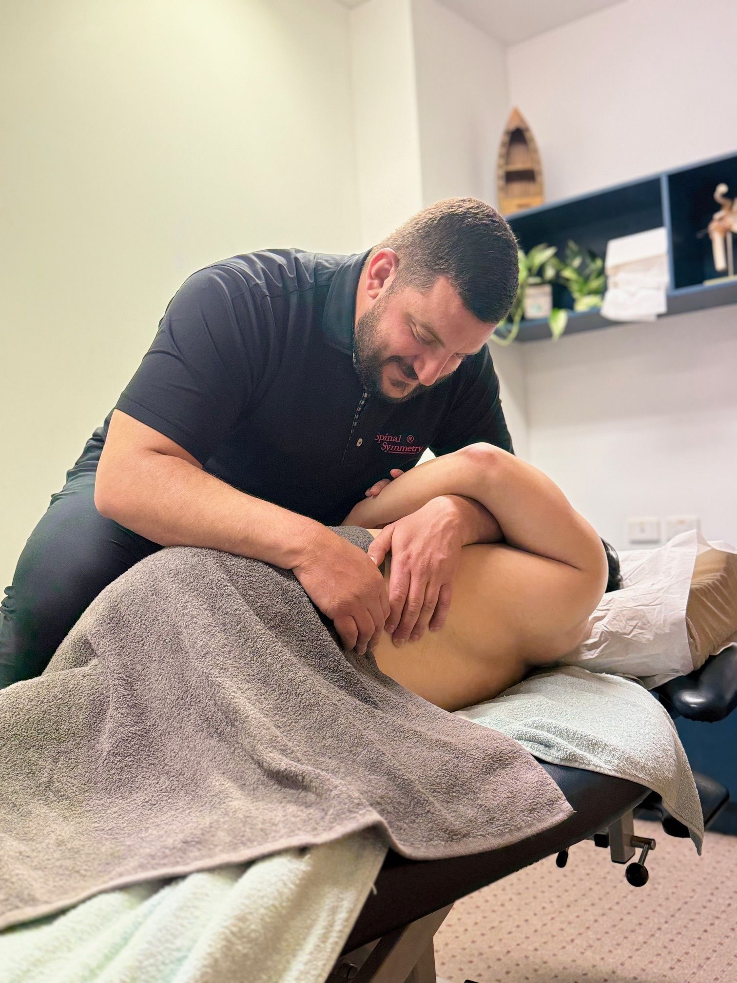 Therapist Giving a Patient a Lower Back Massage on a Treatment Table — Spinal Symmetry In Port Stephens, NSW
