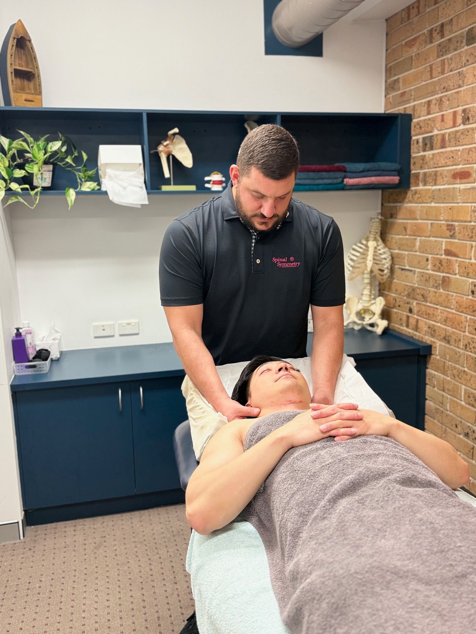 A Man Is Getting A Massage On his Neck  — Spinal Symmetry In Salamander Bay, NSW