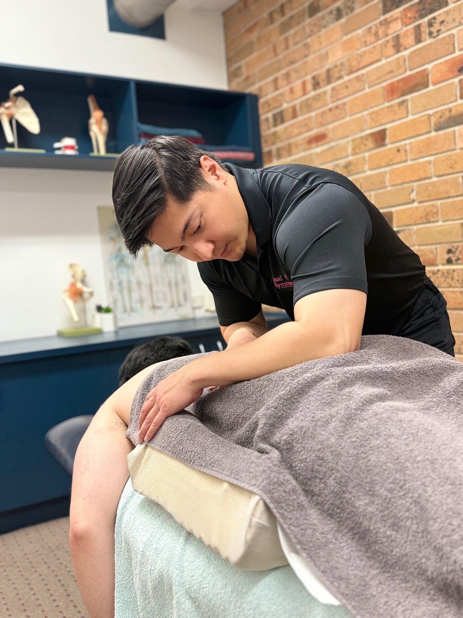 A Man Is Giving  A Massage On A Bed — Spinal Symmetry In Salamander Bay, NSW