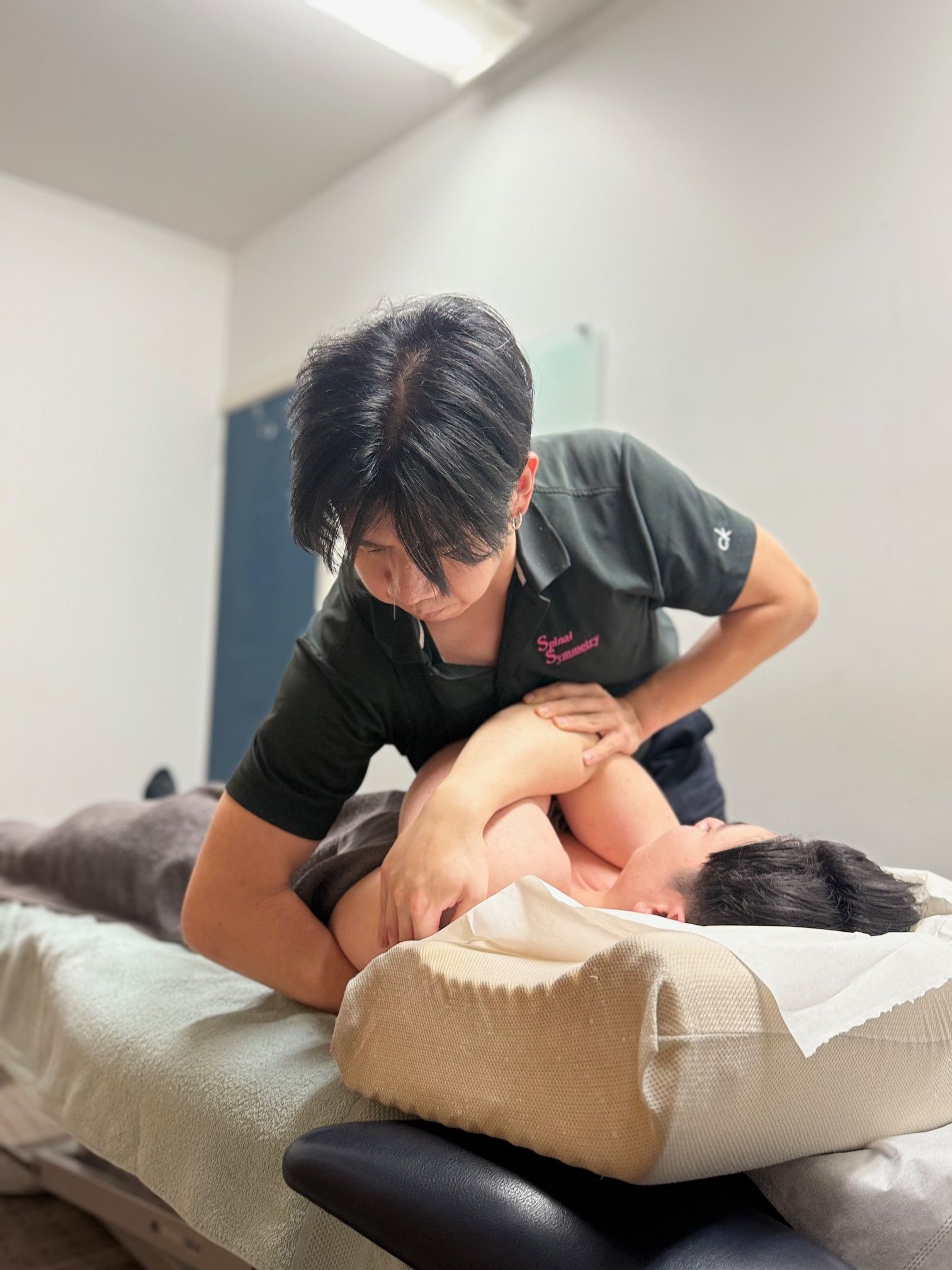 Person Giving Massage to a Person Lying Face Down on a Massage Table — Spinal Symmetry In Dee Why, NSW