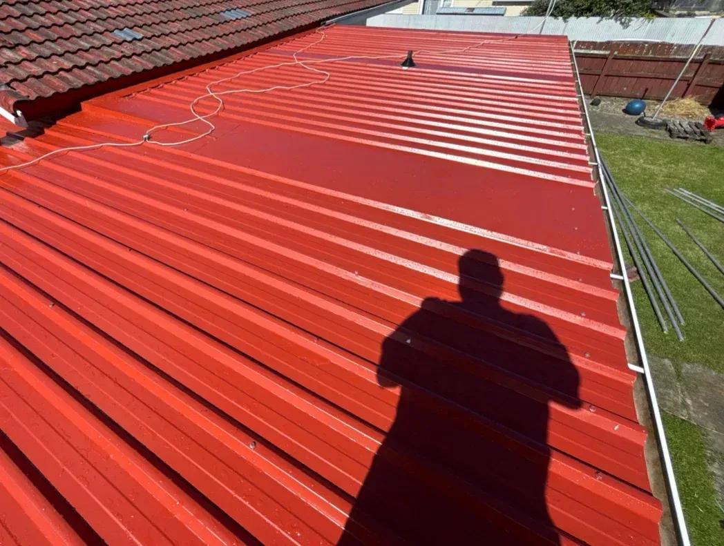 A man wearing a hard hat is working on the ceiling of a building.