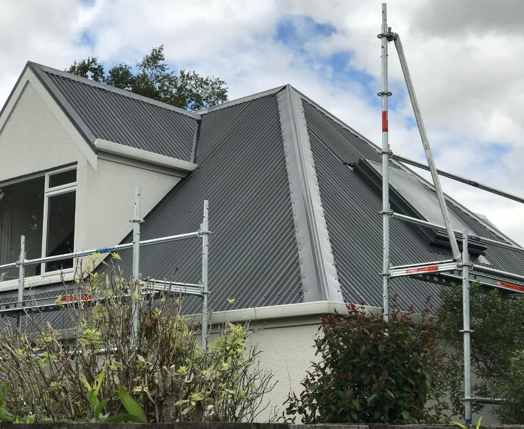 A house with a gray roof and scaffolding around it
