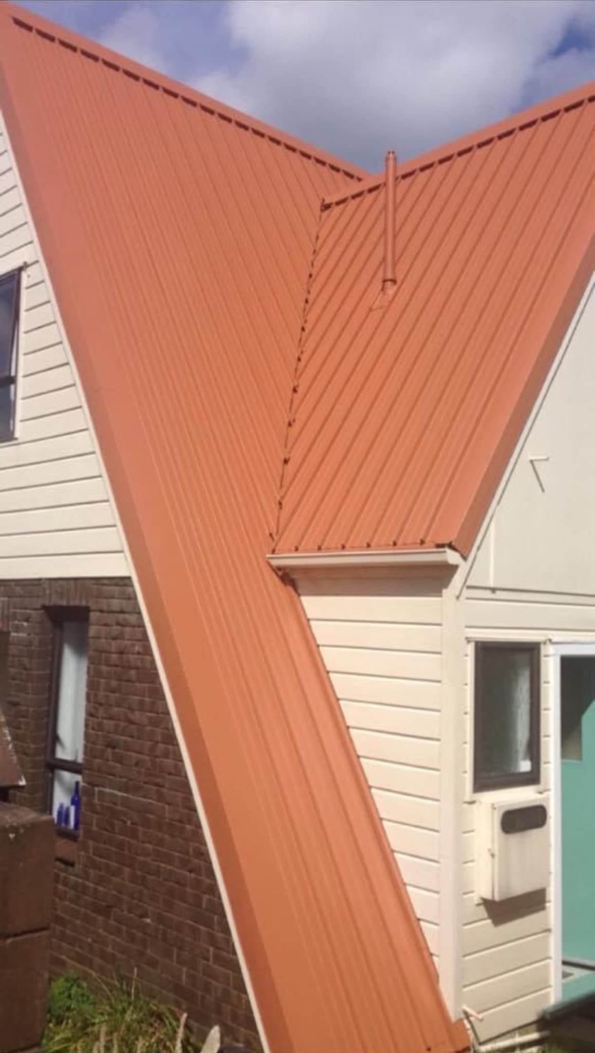 A house with a red roof and white siding