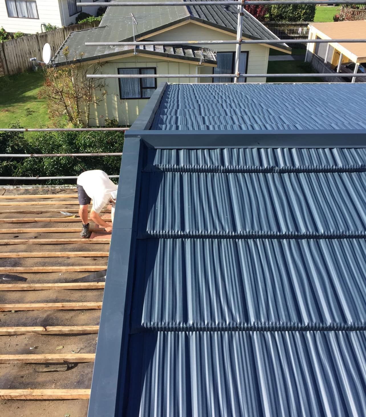 A man is working on the roof of a house