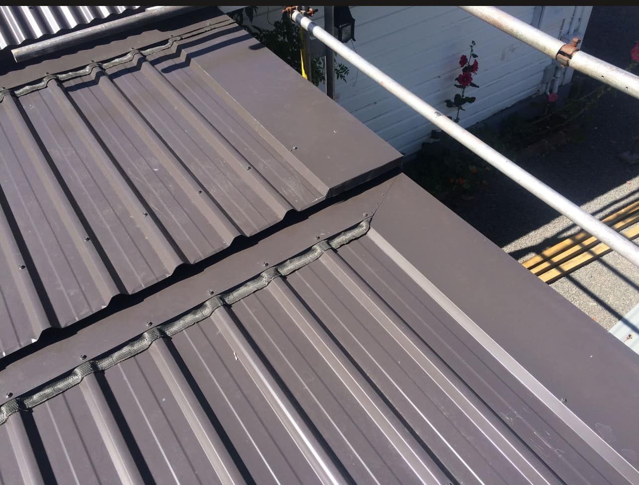 A man is working on a roof with a drill.