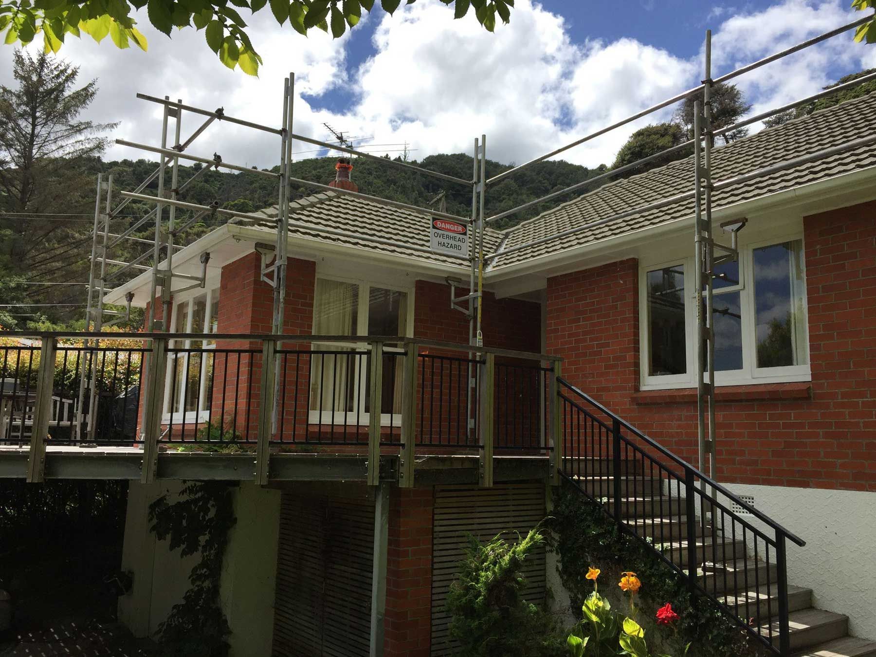 A brick house with stairs and scaffolding on the side of it.