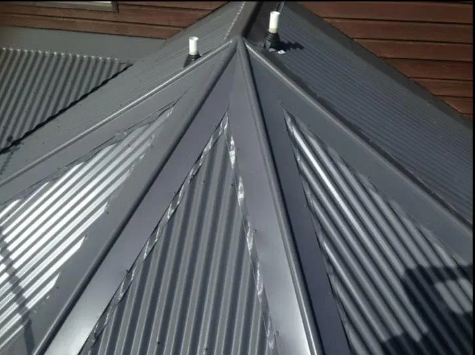 A small house with a gray roof and a window