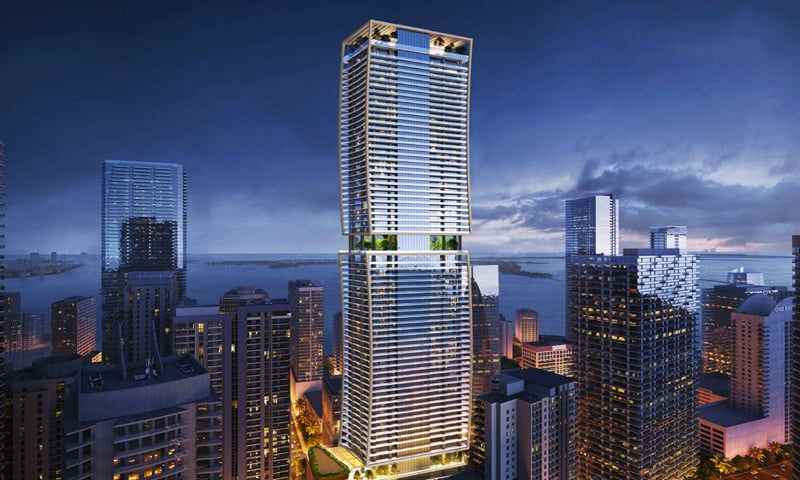 High-rise apartment building at dusk with city and water views.