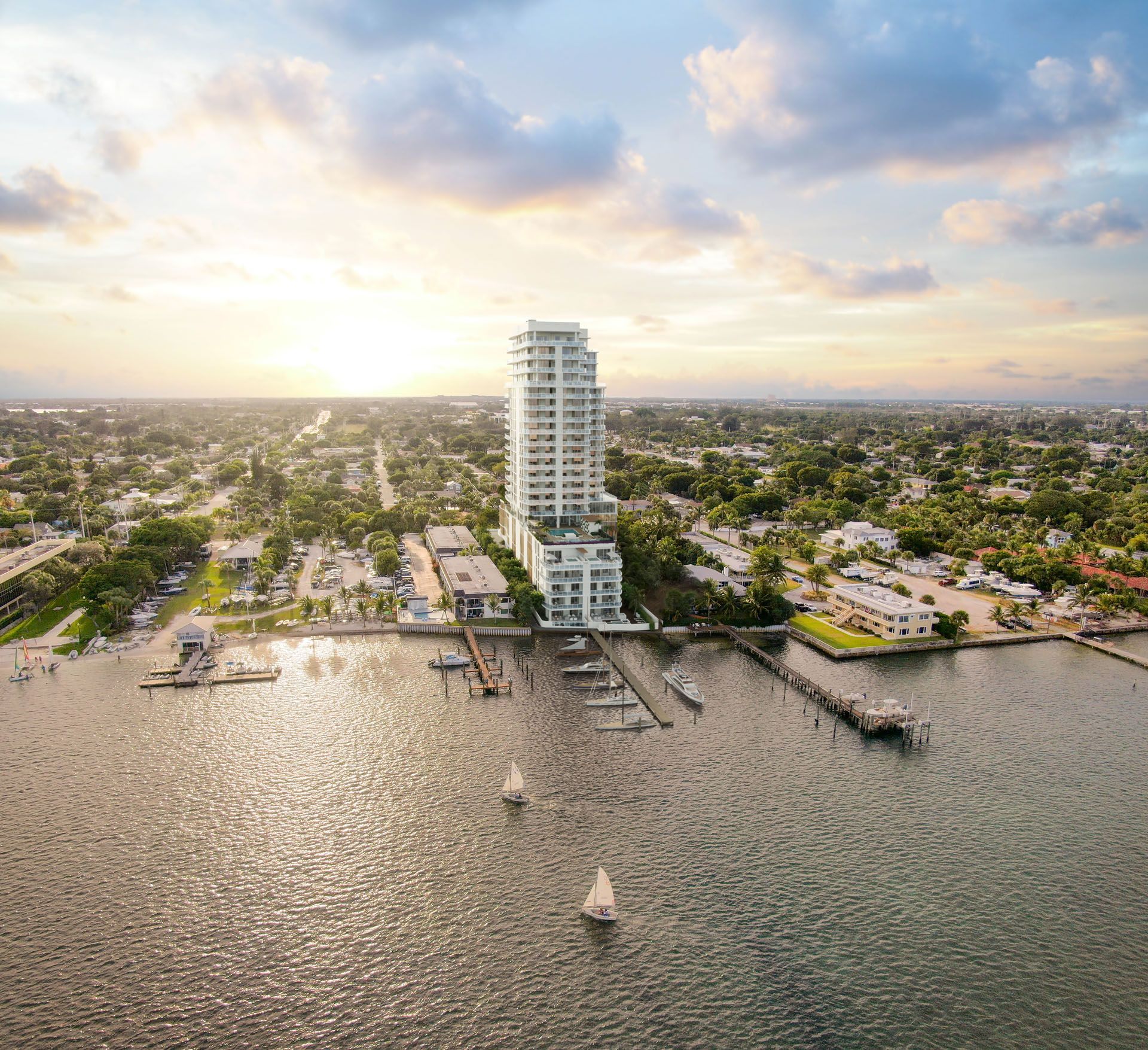 High-rise waterfront building on a sunny day; boats on water, pier, and surrounding buildings.