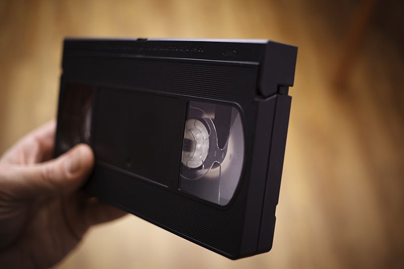 Person Holding Video Cassette Tape Person Holding Video Cassette Tape