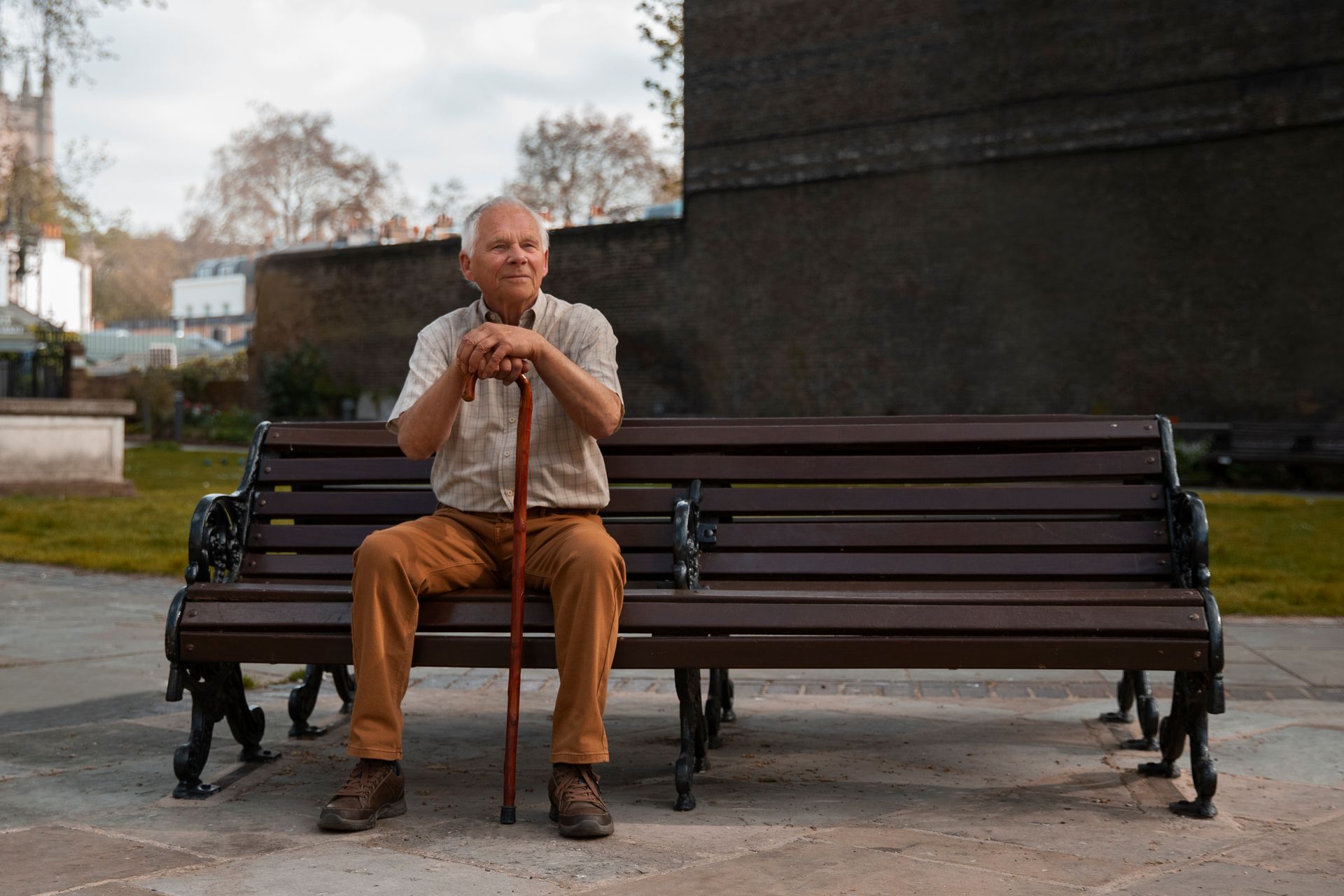 A man is talking to an older man in a wheelchair.