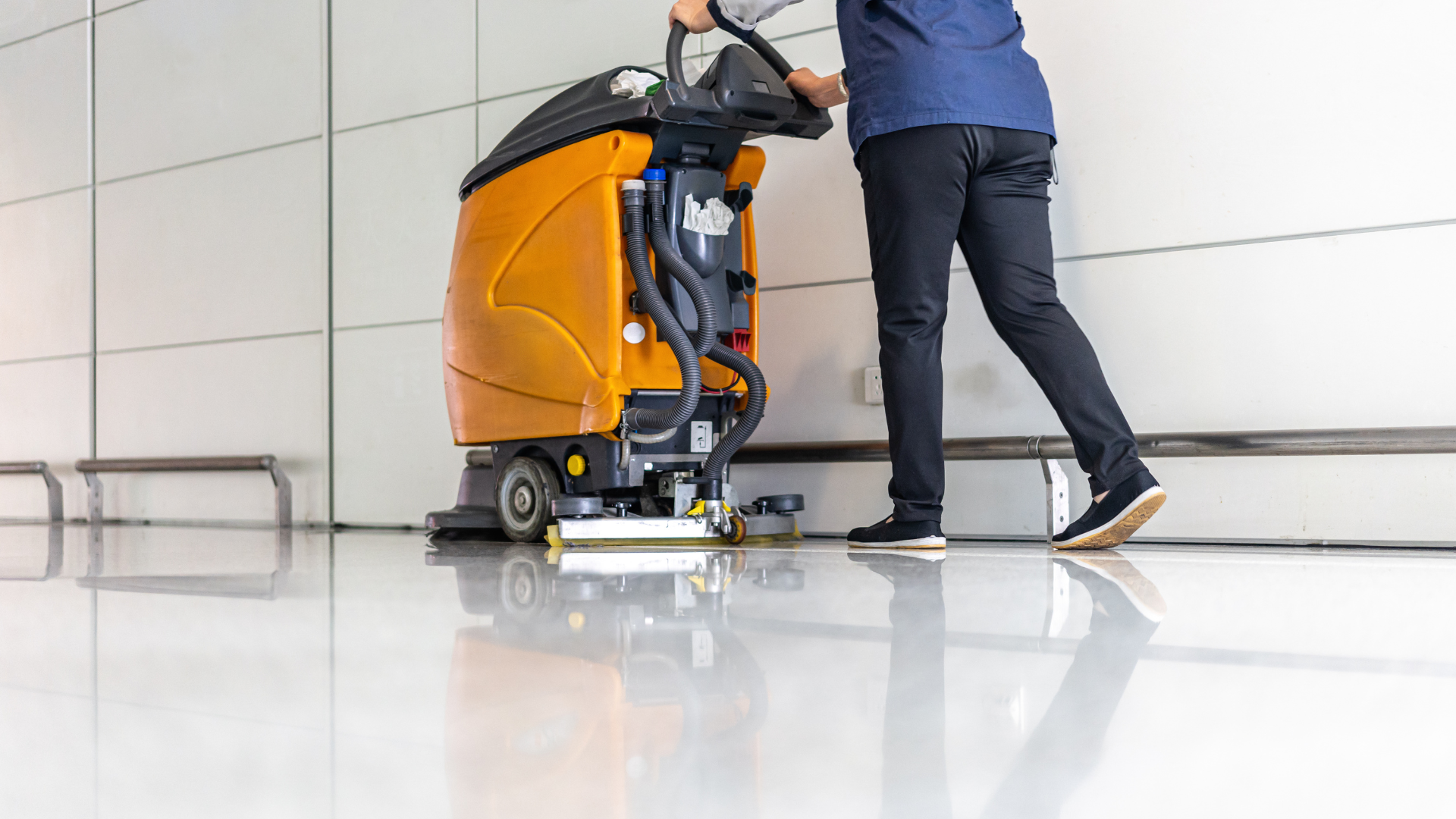 A man is cleaning the floor with a machine.
