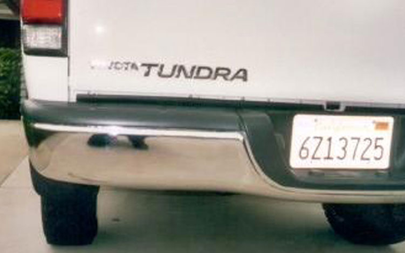 Rear view of a white Toyota Tundra truck with a chrome bumper and California license plate 