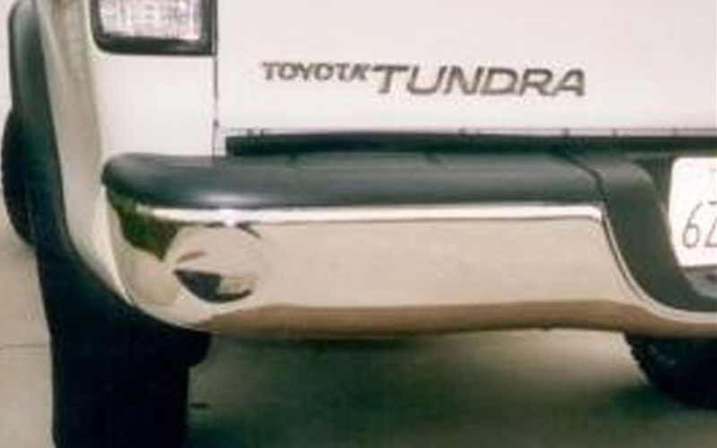 Rear bumper of a white Toyota Tundra truck with a chrome bumper, black accents, and 