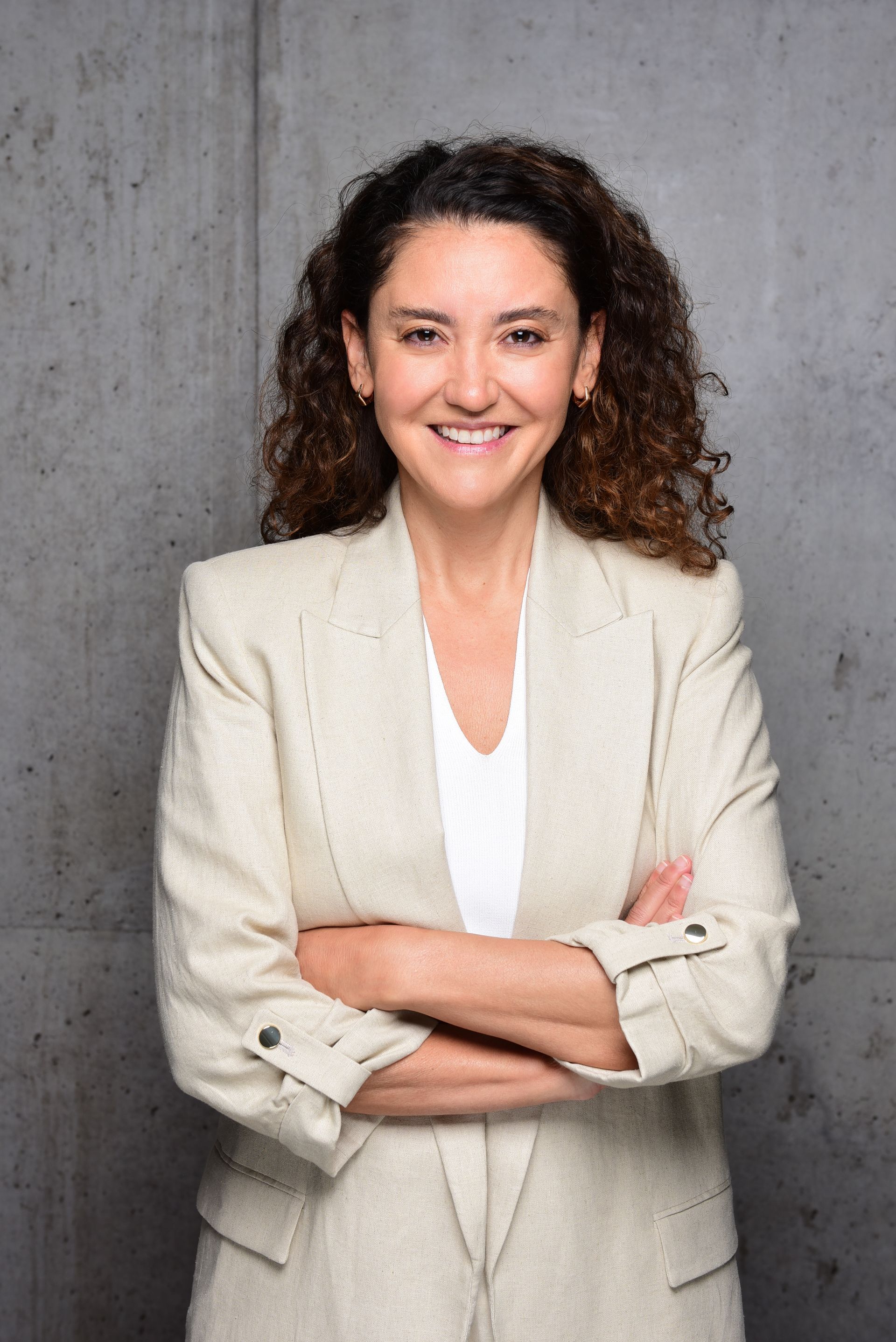 Eine Frau in einer grünen Jacke steht vor einem Baum.