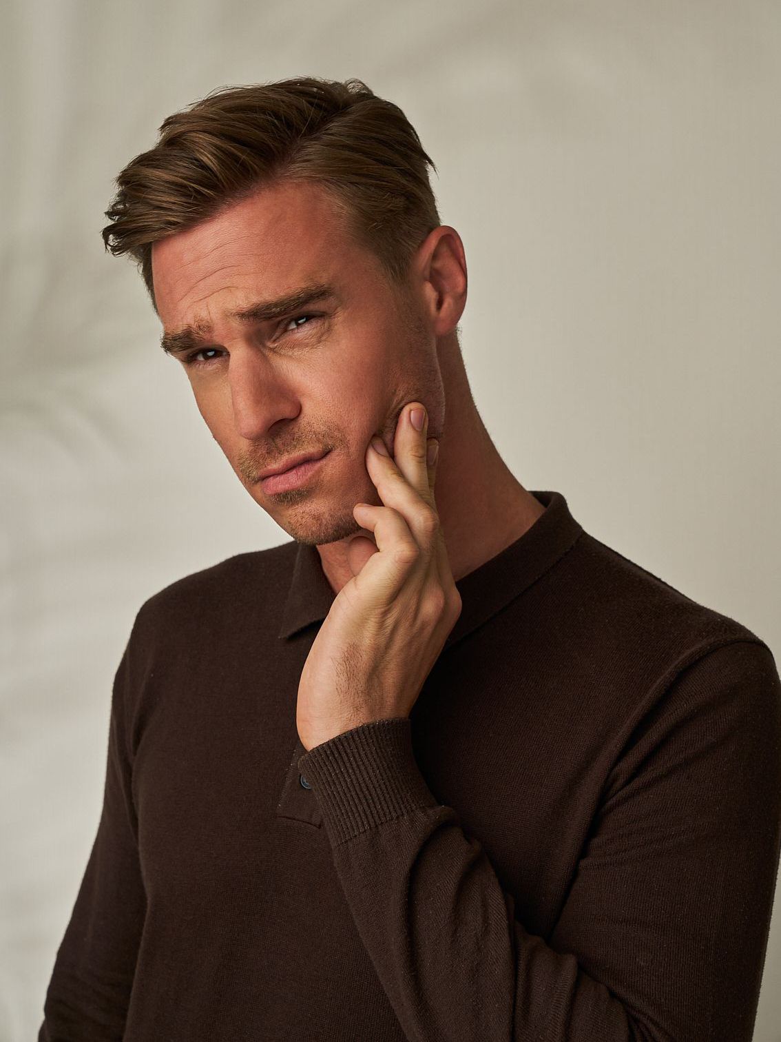 ein Mann ohne Hemd hält seinen Finger an seinem Gesicht. Muskelrelaxans botox Behandlung 